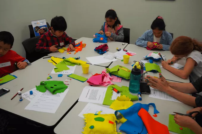 Kids around a table sewing stuffed animals
