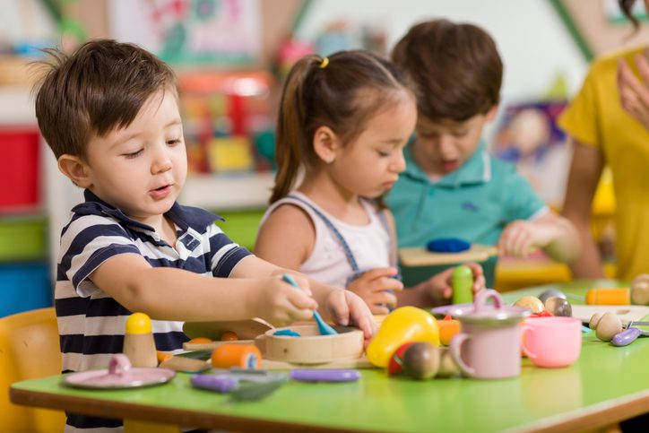 Preschoolers sitting at a table playing with playdoh