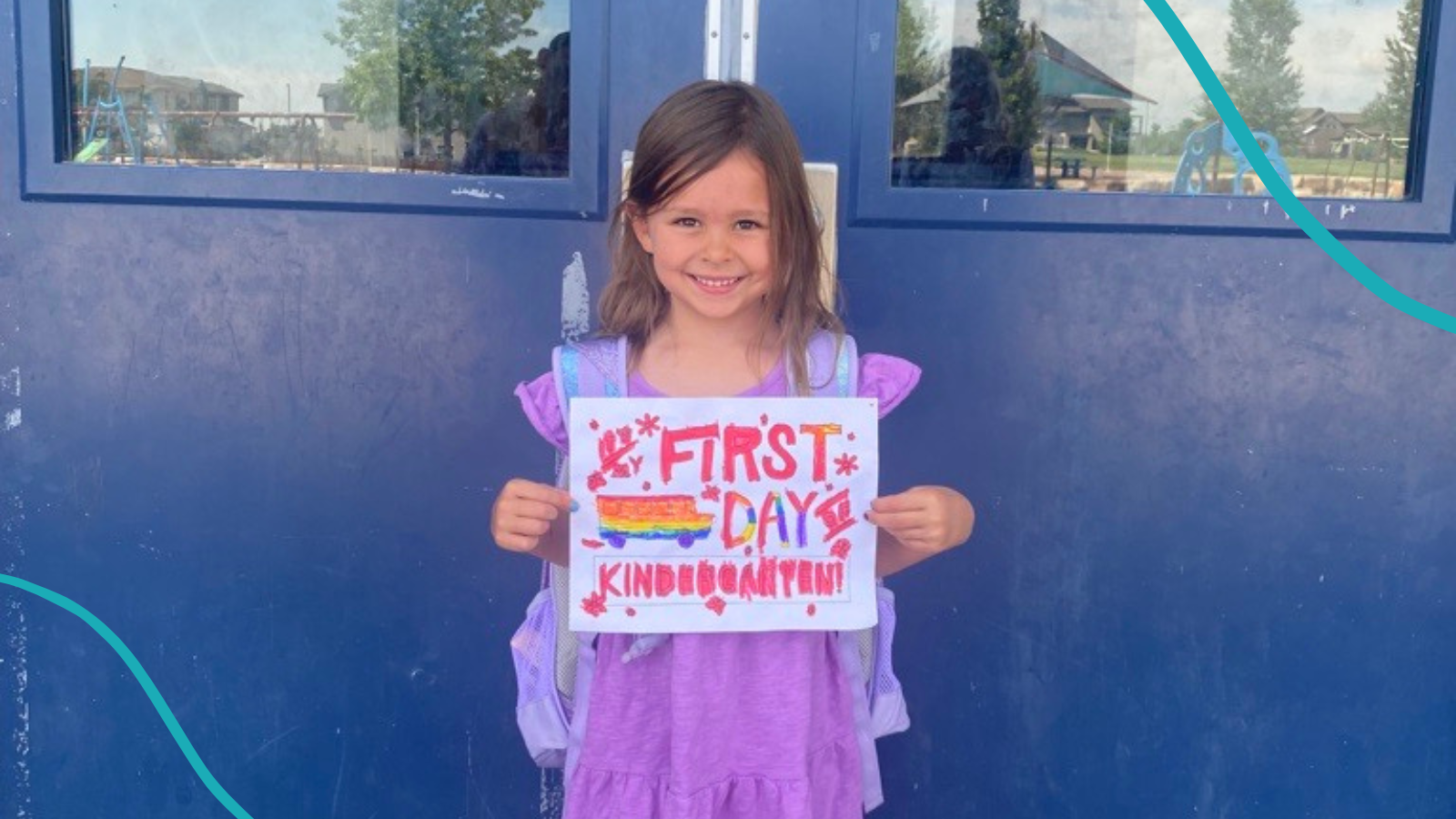 Girl age five standing in front of school doors holding a sign that says First Day of Kindergarten