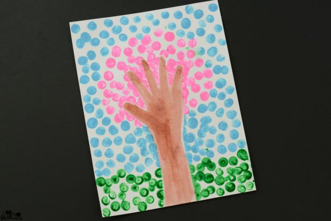 Painted tree made from fingerprints and a tracing of a hand