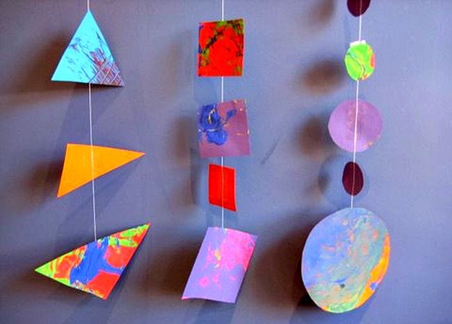 Colorful painted triangles, squares, and circles strung on garlands