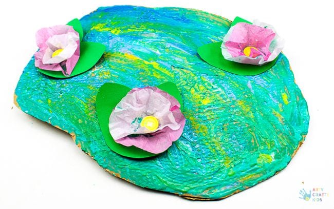 Paper pond colored with swirled paint, with tissue paper water lilies on top in this example of kindergarten art