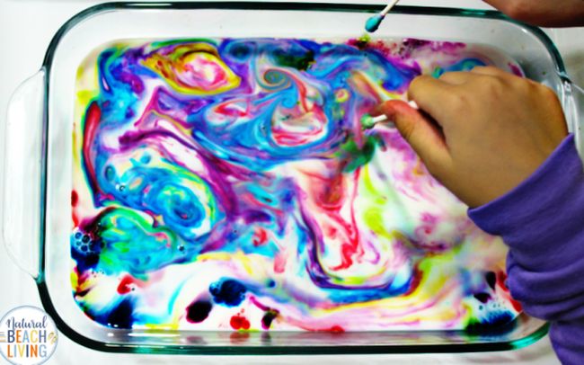 Student swirling a pan of colorful milk