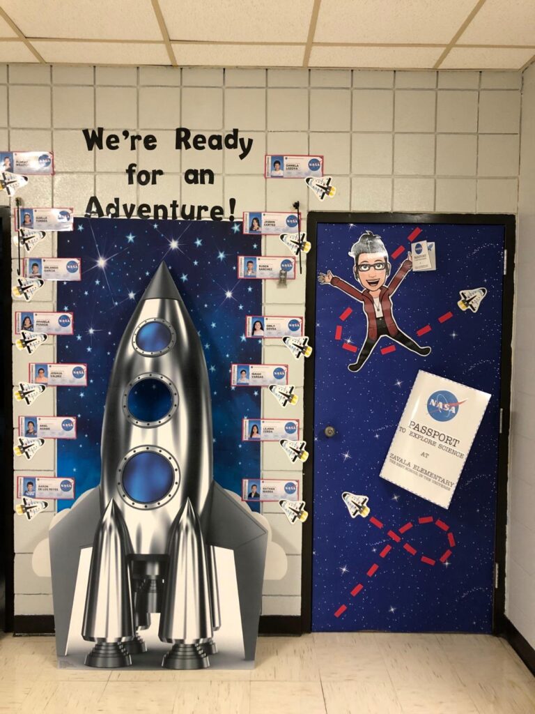 Large silver space shuttle next to a decorated classroom door