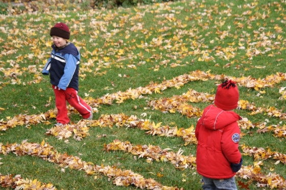 kids playing in a leaf maze 