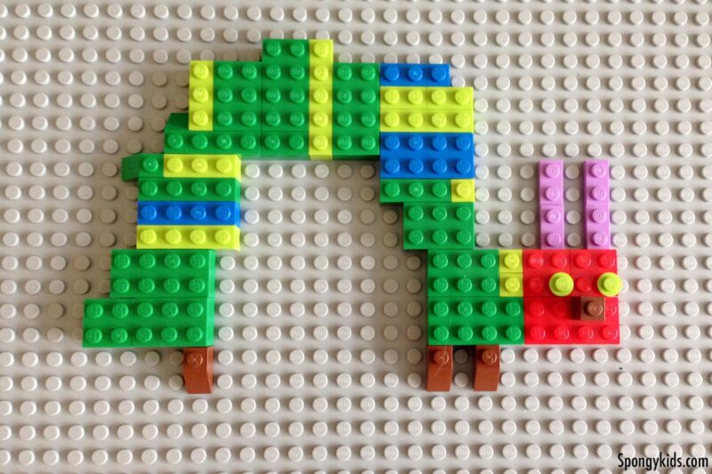 A caterpillar is made from legos on a gray baseplate. 