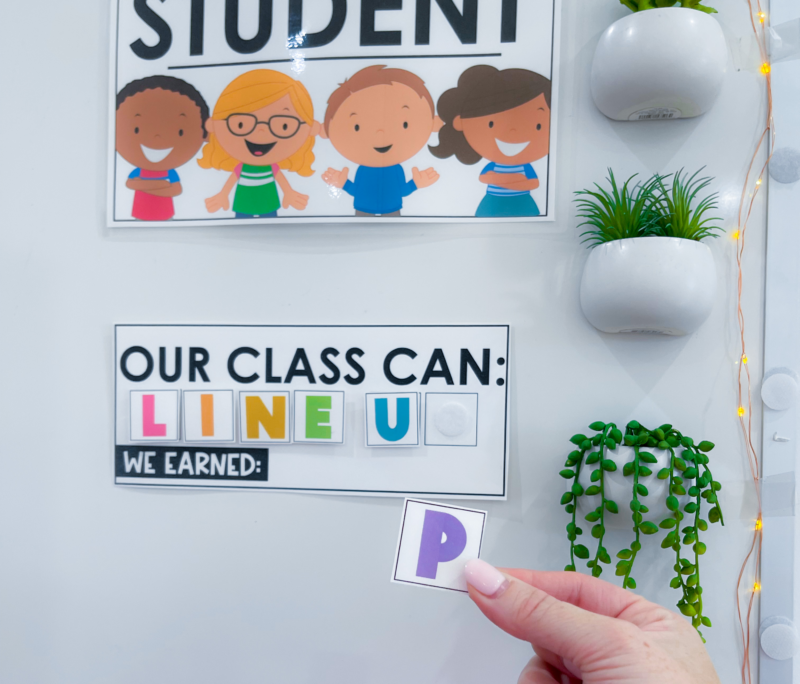 Classroom Management Game: Line Up Line-up classroom management game on the wall with a teacher's hand holding the letter P