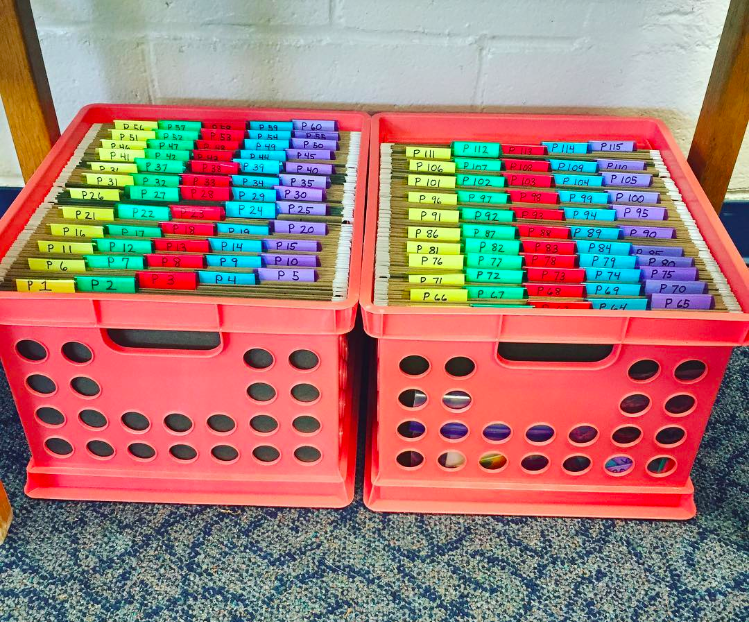 Coral colored pastic milk crates filled with student files