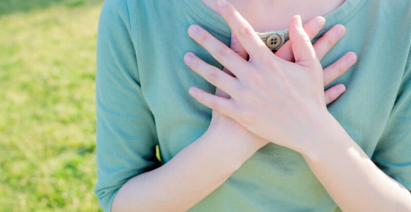 A student's hands lay crossed on their chest