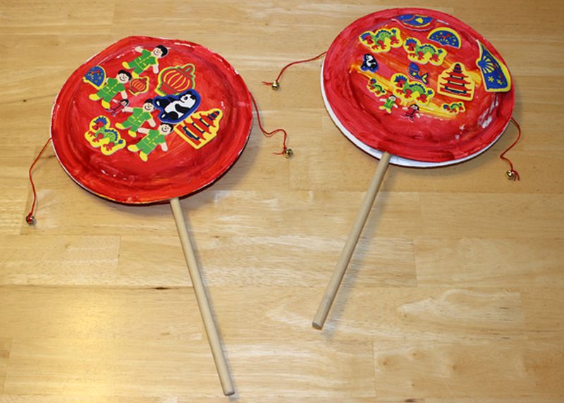 Chinese pellet drums made from paper plates, string, and wooden dowels