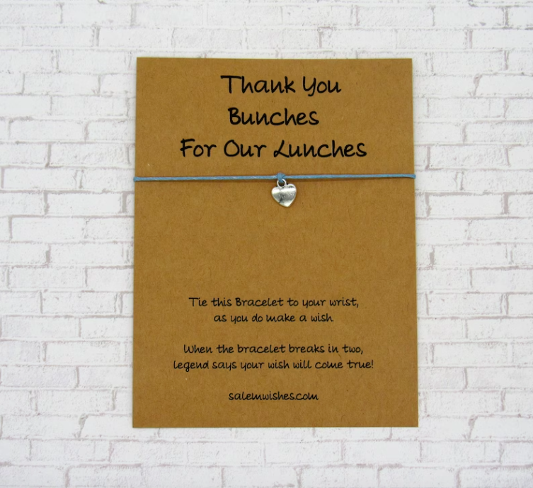 A simple bracelet made from a blue cord and a silver heart is displayed on a card that says thank you bunches for the lunches