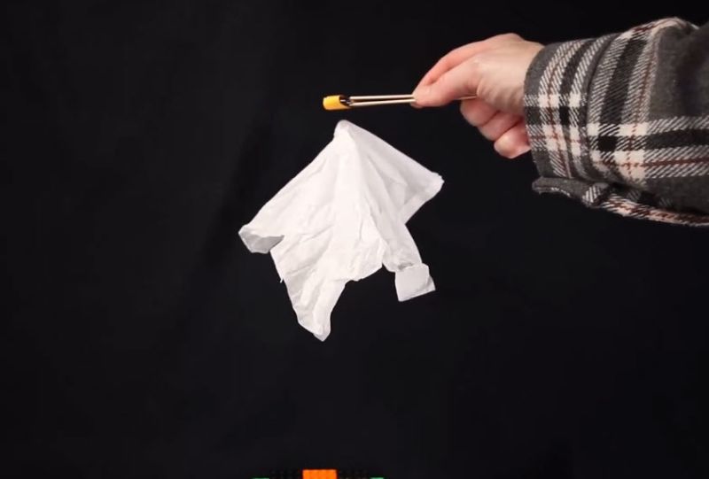 Child using a magnet to make a tissue paper "ghost" float in the air