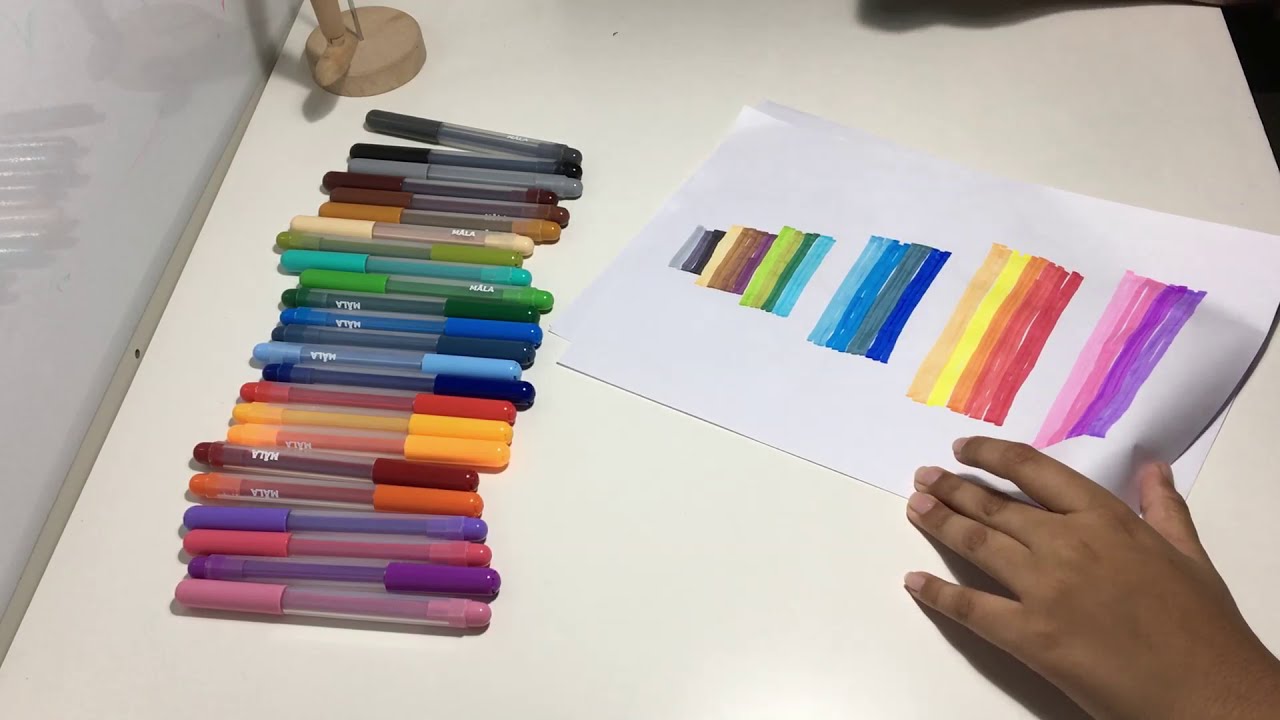 A hand is shown drawing with multi-colored markers.