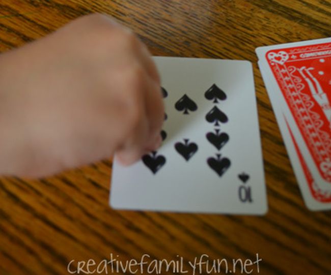 Child flipping a playing card from a deck (Math Card Games)