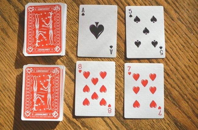 Two stacks of cards with two cards laid face up next to each