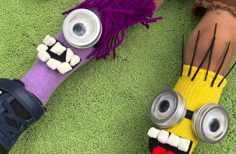 Purple and yellow DIY minion socks with google eyes, marshmallow teeth, and yarn hair