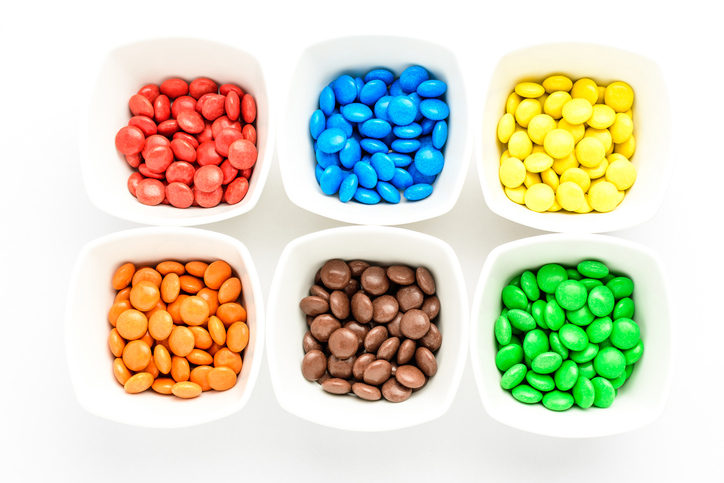 Red, blue, yellow, orange, brown, and green candies are sorted by color.