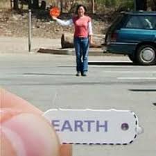 small earth picture and person standing far away from them to show the sun 