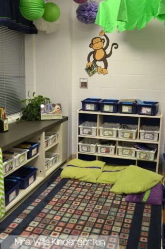 Center stations in the corner of a kindergarten classroom with a monkey decal on the wall 