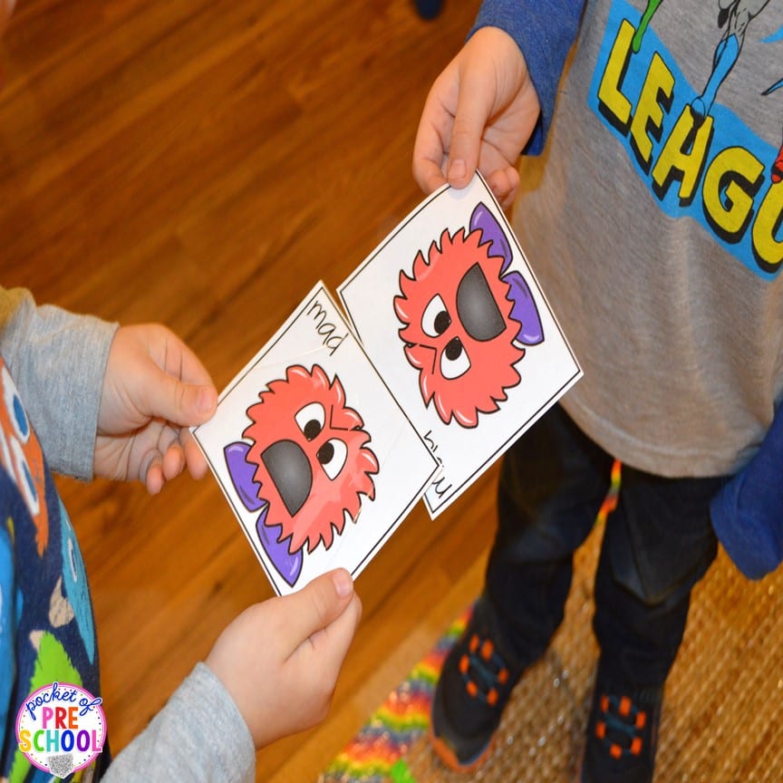 Two preschoolers showing each other matching monster cards as an example of social emotional activities