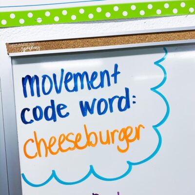 Classroom white board with text 'movement code word: cheeseburger'