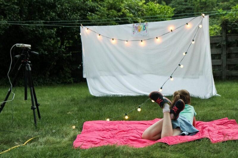 Child watching outdoor movie- summer activities for kids