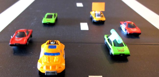 Toy cars lined up on a race track (NASCAR Teaching Ideas)