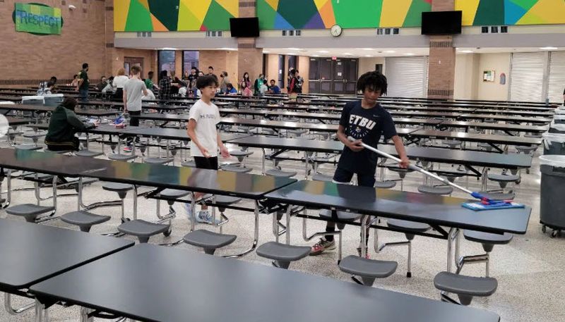 Students helping to set up and clean lunch tables in honor of National Custodian Day