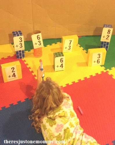 child with nerf gun shooting at math flash cards