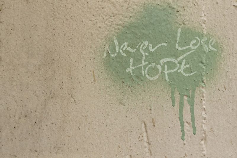 Splotch of green paint with the words "Never Lose Hope" scrawled in it