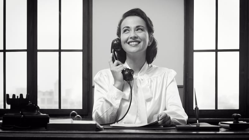 No emails parent teacher --Smiling vintage receptionist working at office desk and smiling-