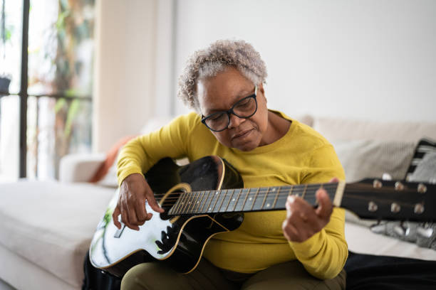 An older woman playing the guitar as an example of ways to introduce yourself to students 