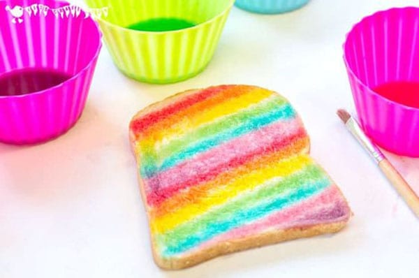 A piece of bread is painted with rainbow stripes.