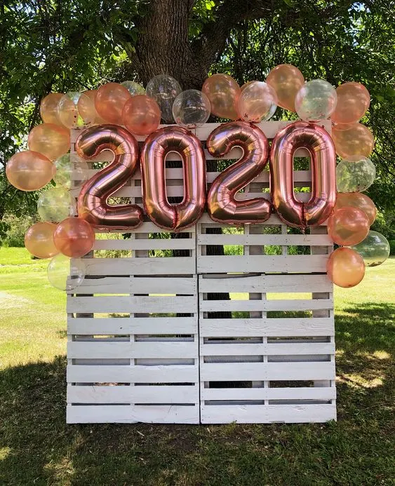 Photo backdrop made from pallets and balloons as an example of kindergarten graduation ideas
