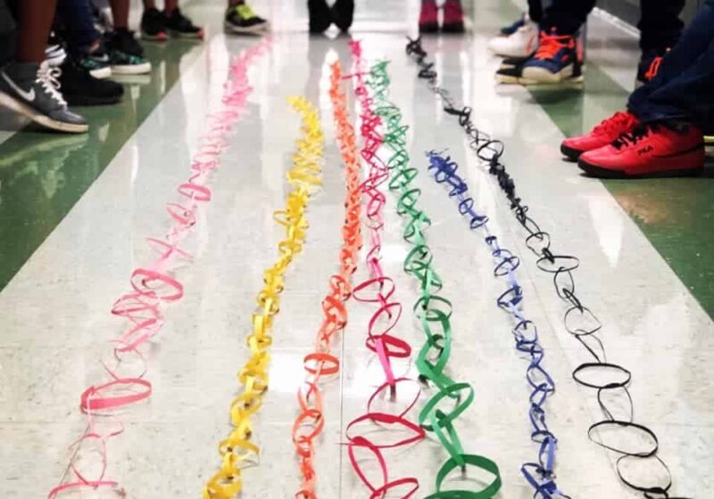 colorful plastic rings joined together into long chains by color on a white floor