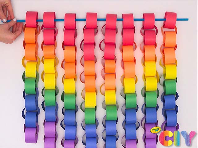 A bright, colorful paper chain hangs from a dowel