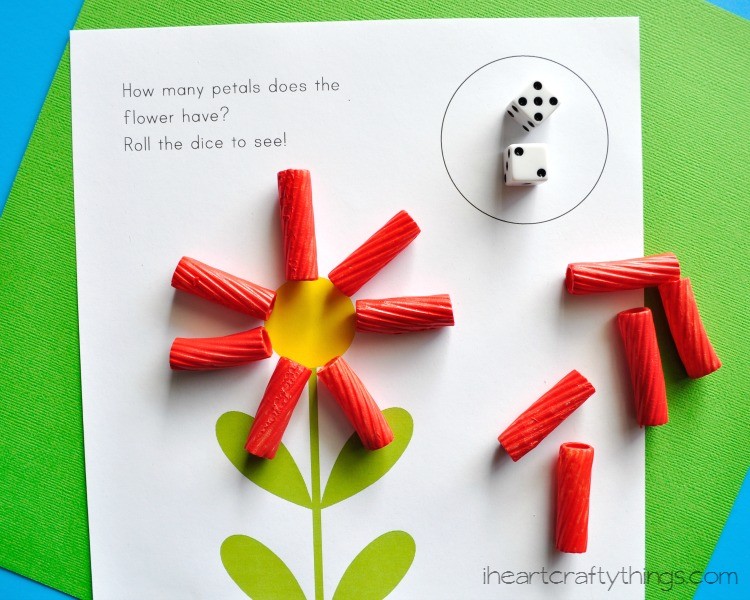 A preschool math worksheet shows flowers with petals made from pasta noodles