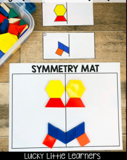 a symmetry mat with colorful pattern blocks laid out with shapes on either side of the center line