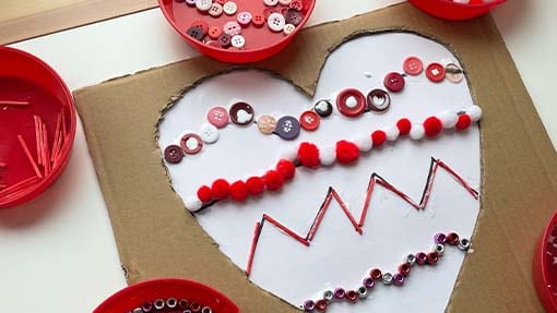 Different shape lines are shown on a heart. Buttons and beads are lining the shapes. 