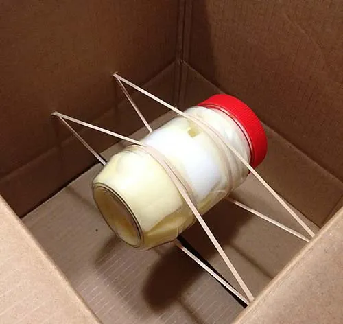 peanut butter jar tied to a box with rubber bands 