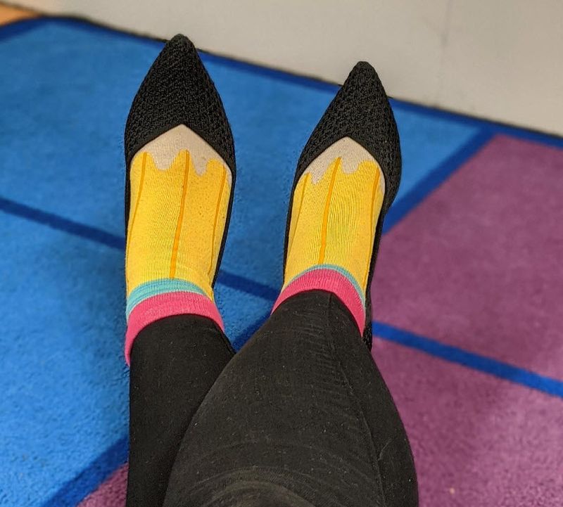 Pair of socks that look like pencils, worn with black pointed toe flats