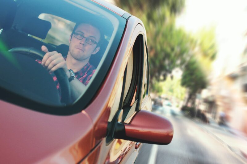 man driving red car 