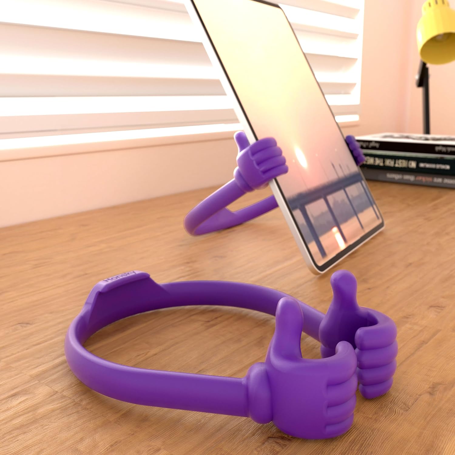 Adjustable phone stand that looks like two thumbs up, empty and holding a tablet