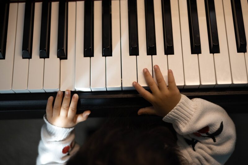 A young child's hands on a piano keyboard