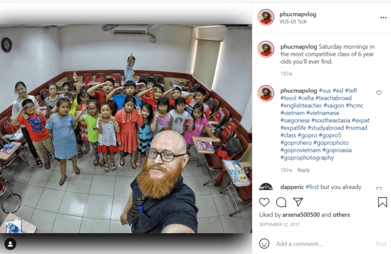 Teacher taking selfie with a large group of young students in classroom