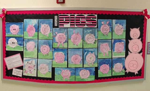A bulletin board is shown that has many drawings of pigs on it.