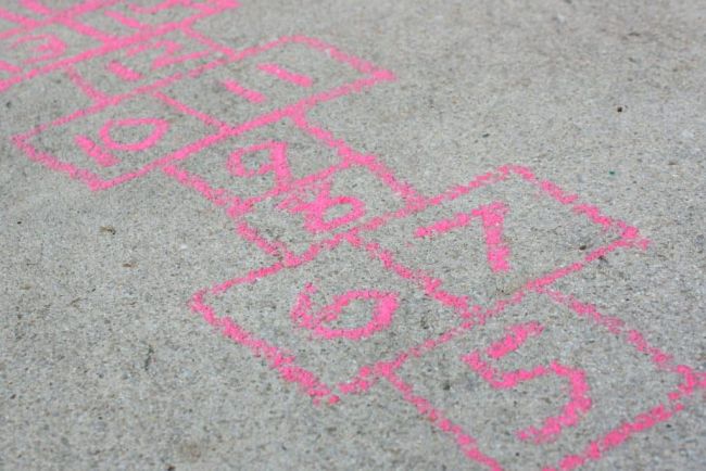Hopscotch board drawn on a sidewalk using pink chalk, used for kindergarten math games