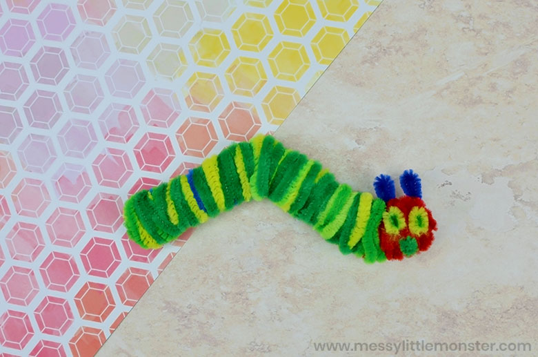 A green caterpillar is made from twisted pipe cleaners in this example of Very Hungry Caterpillar activities. 