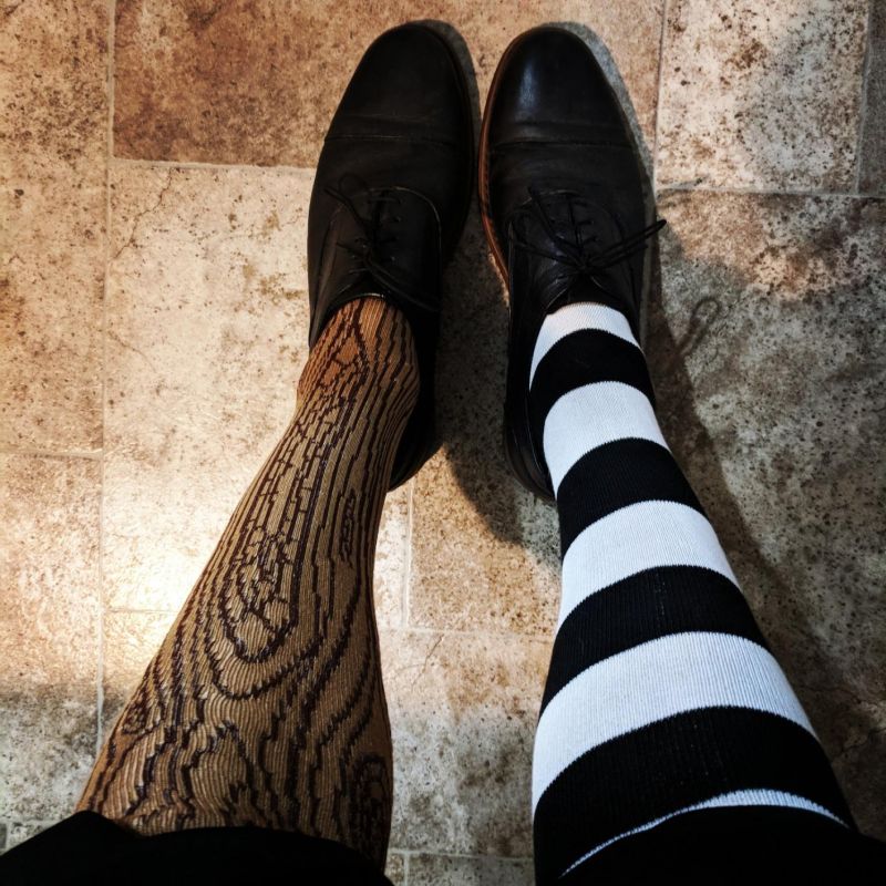 Set of socks with one black and white striped leg and one with a wood grain pattern
