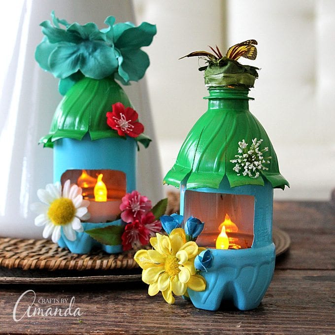 Bottles are painted and decorated to look like fairy houses. They have battery operated tea lights inside. 